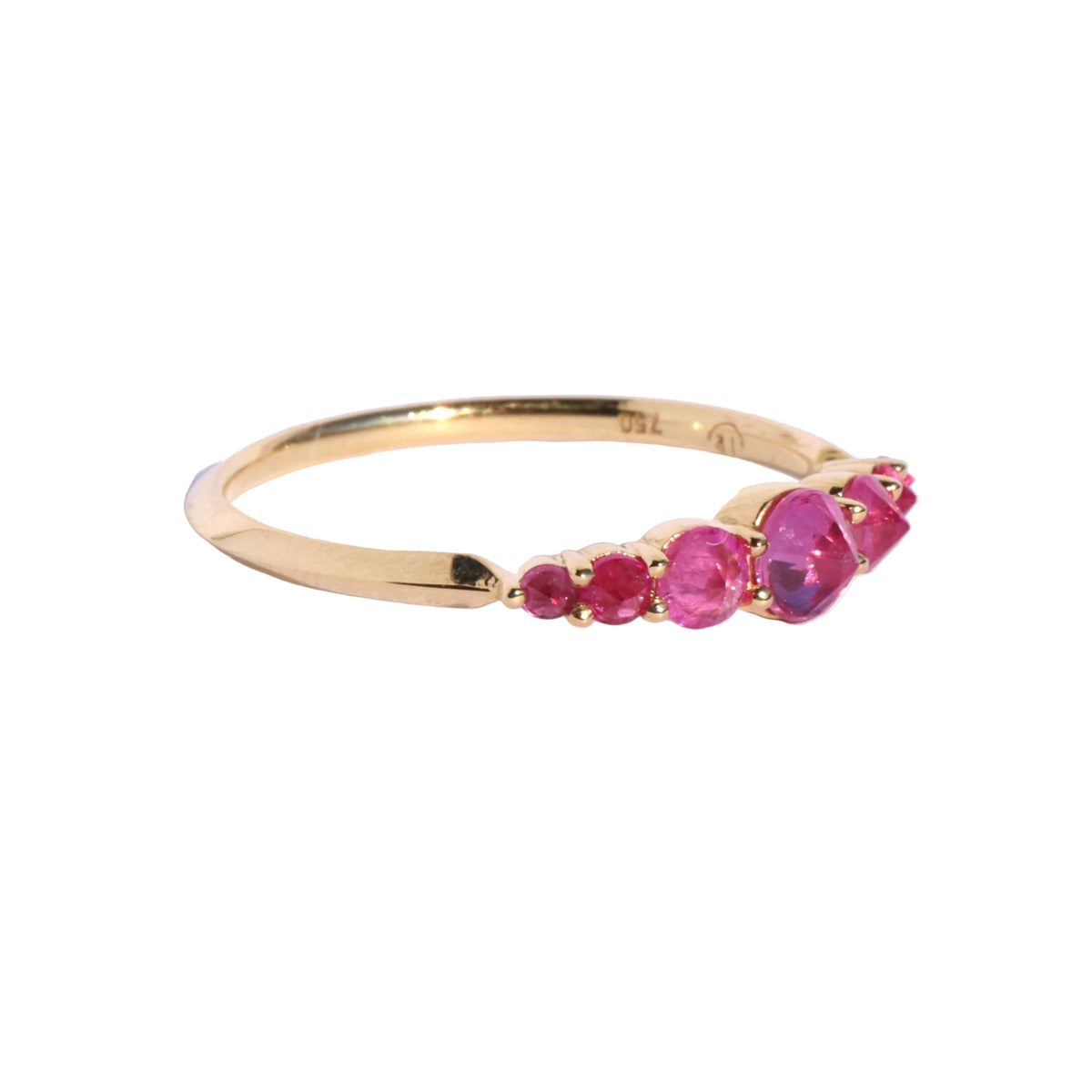 Spiky seven stone ruby and gold ring , from side, on white background by Tamsin Rasor