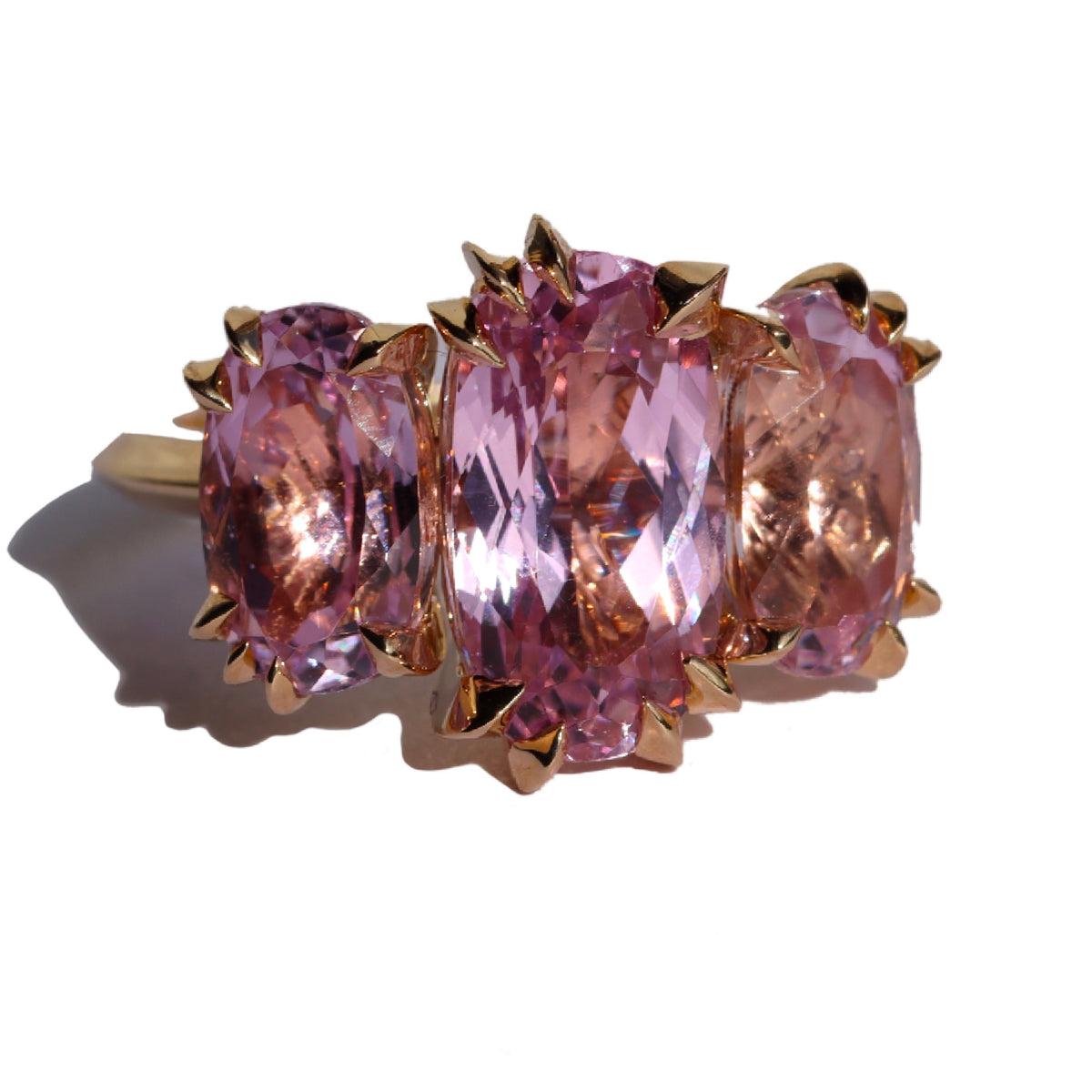 Large cocktail ring with three pink Kunzite gemstones and asymmetric knife edged gold setting, by Tamsin Rasor, on a white background
