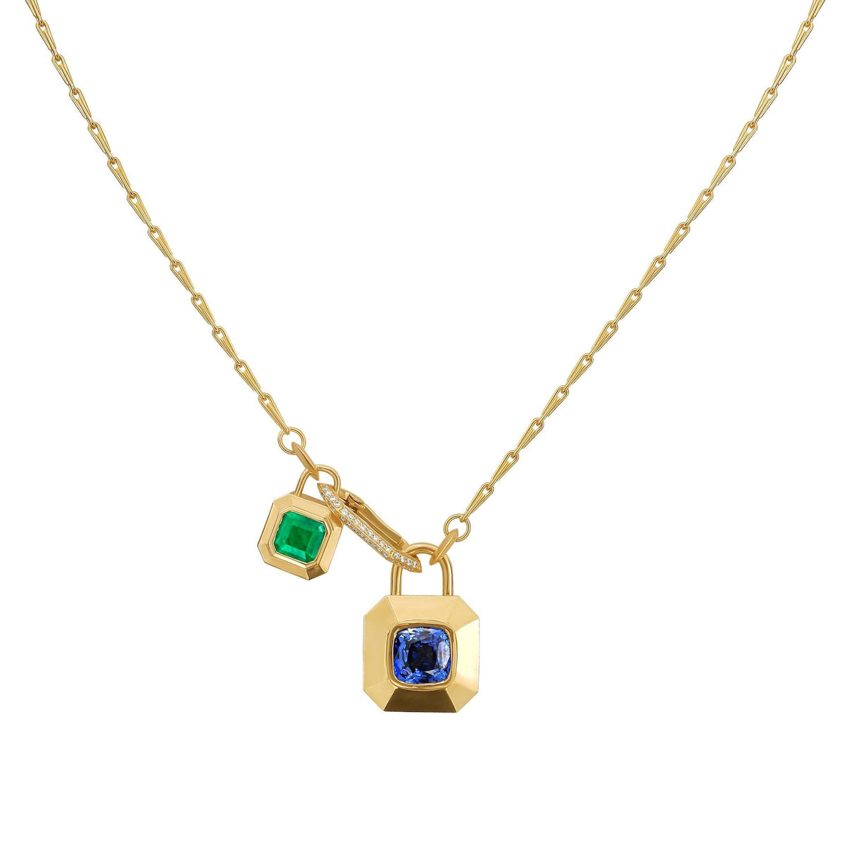 A gold chain necklace featuring two hanging padlock-shaped charms, one with an emerald and the other with a blue sapphire, set against a plain white background, by Tamsin Rasor Fine Jewelry