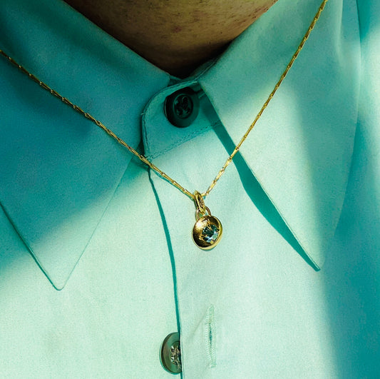blue diamond compass pendant necklace shown on model over mint green collared shirt