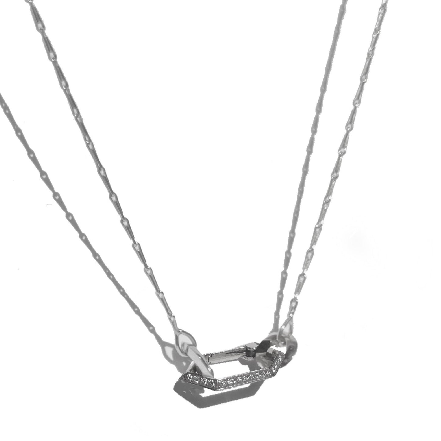 Platinum and diamond clip necklace on white background