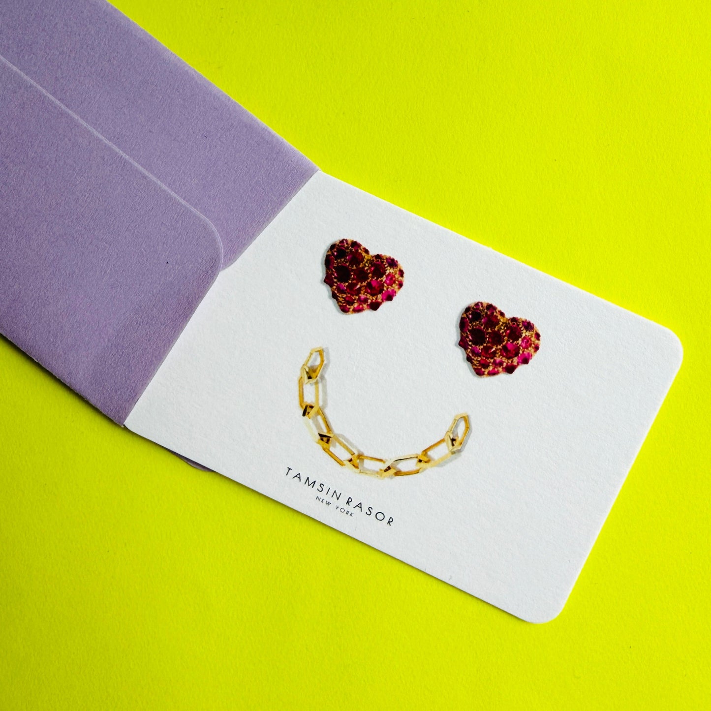 Tamsin Rasor gift card peeking out of purple envelope on neon yellow background