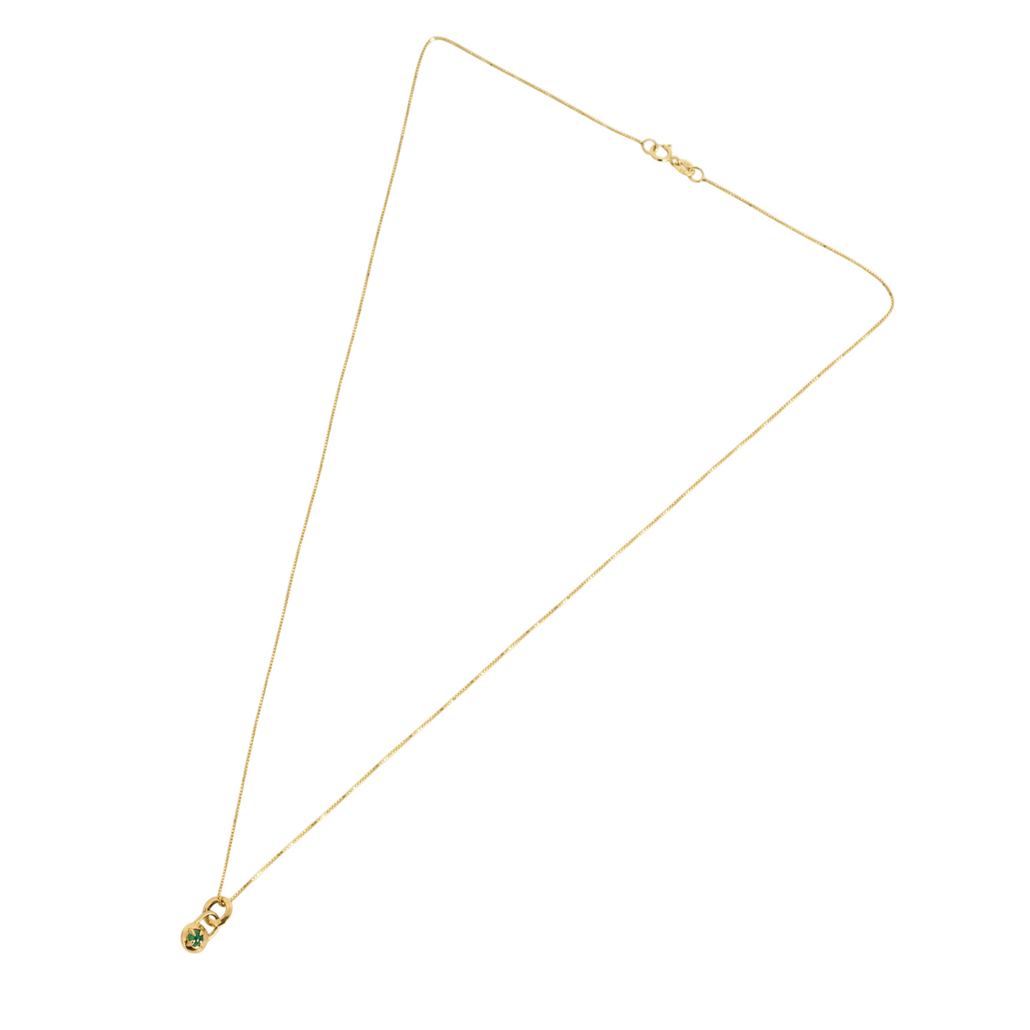 Flat lay of a gold necklace with a compass pendant featuring a natural emerald cabochon against a white background by Tamsin Rasor