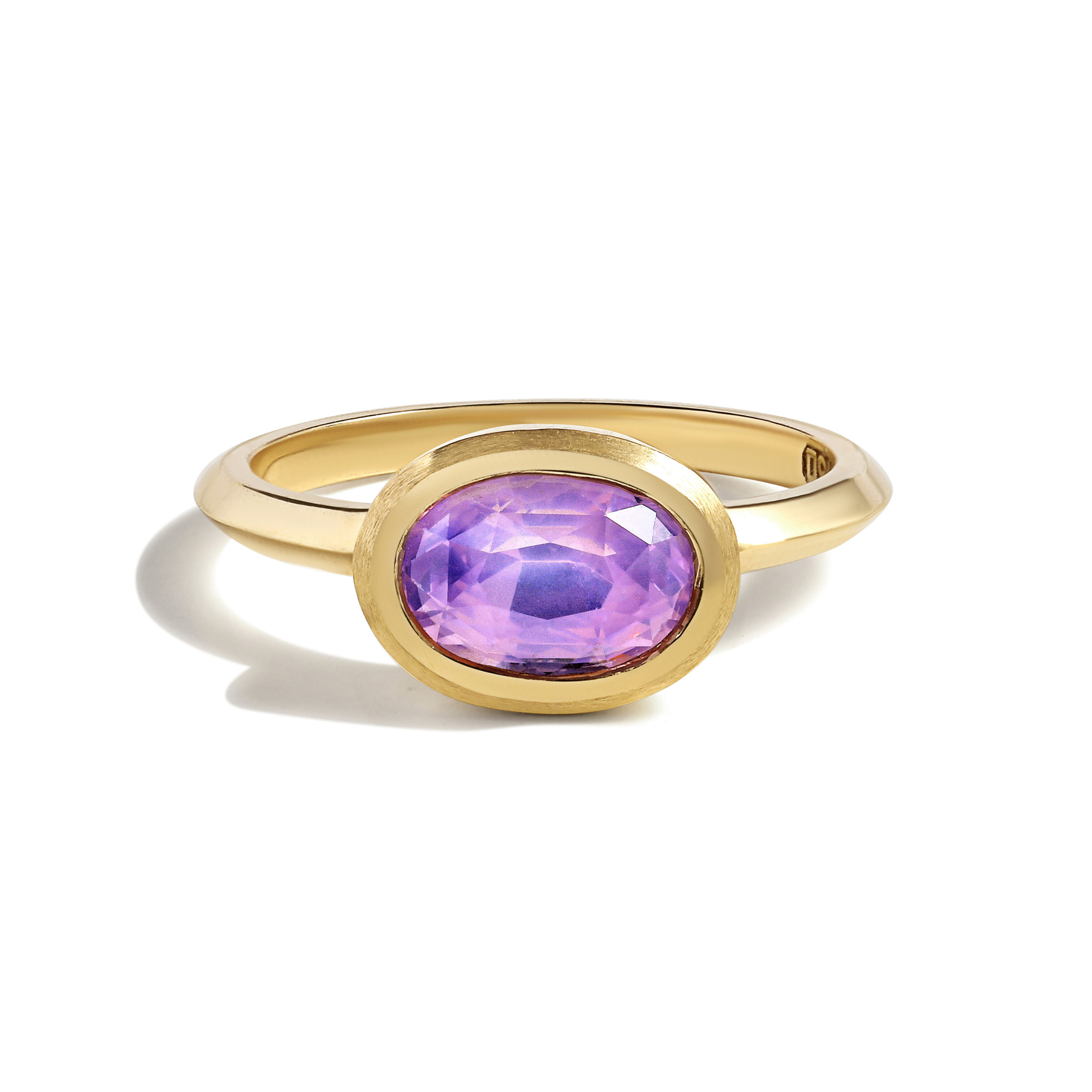 Gold ring with a purple sapphire gemstone  by Tamsin Rasor on a white background