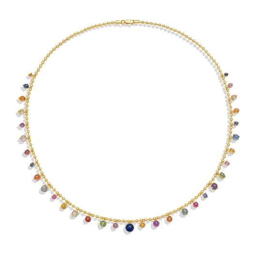 A gold bead chain necklace featuring a fringe of multi color sapphire cabochon gem drops, set in gold prong settings, arranged in a gentle curve against a white background with a soft shadow. By Tamsin Rasor