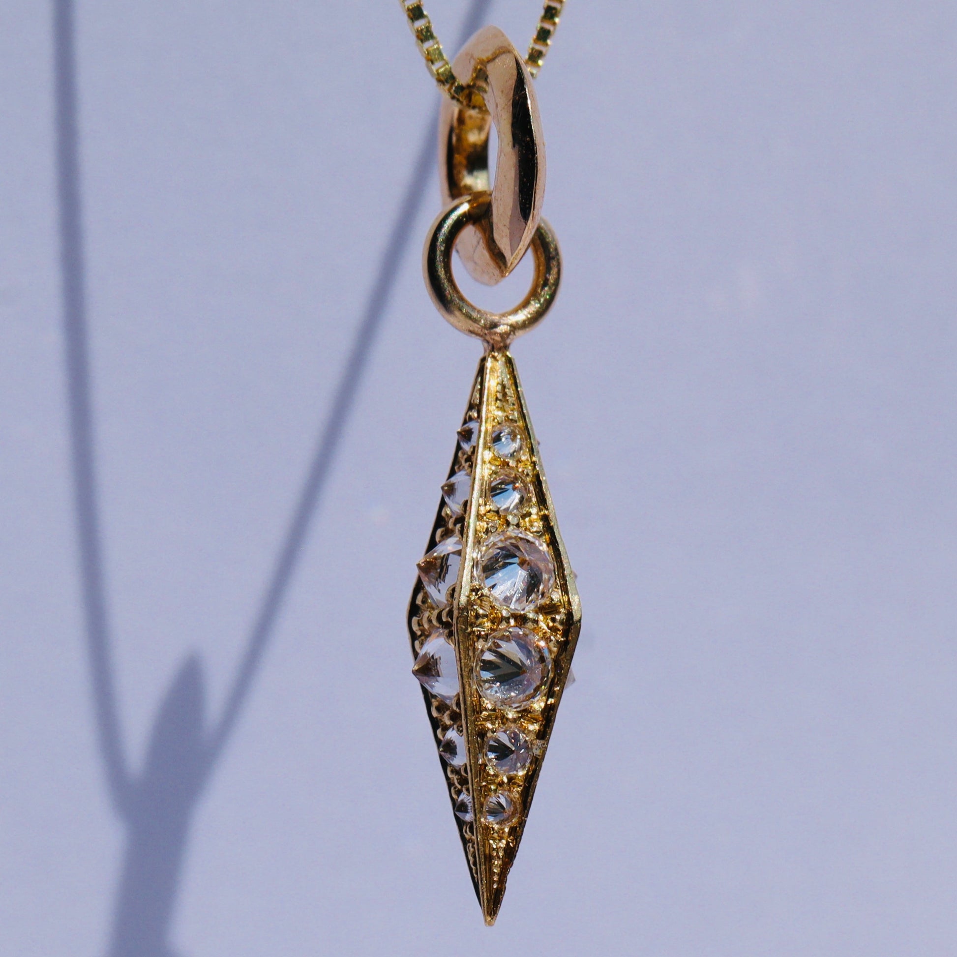 barbed diamond obelisk pendant on chain against a white background