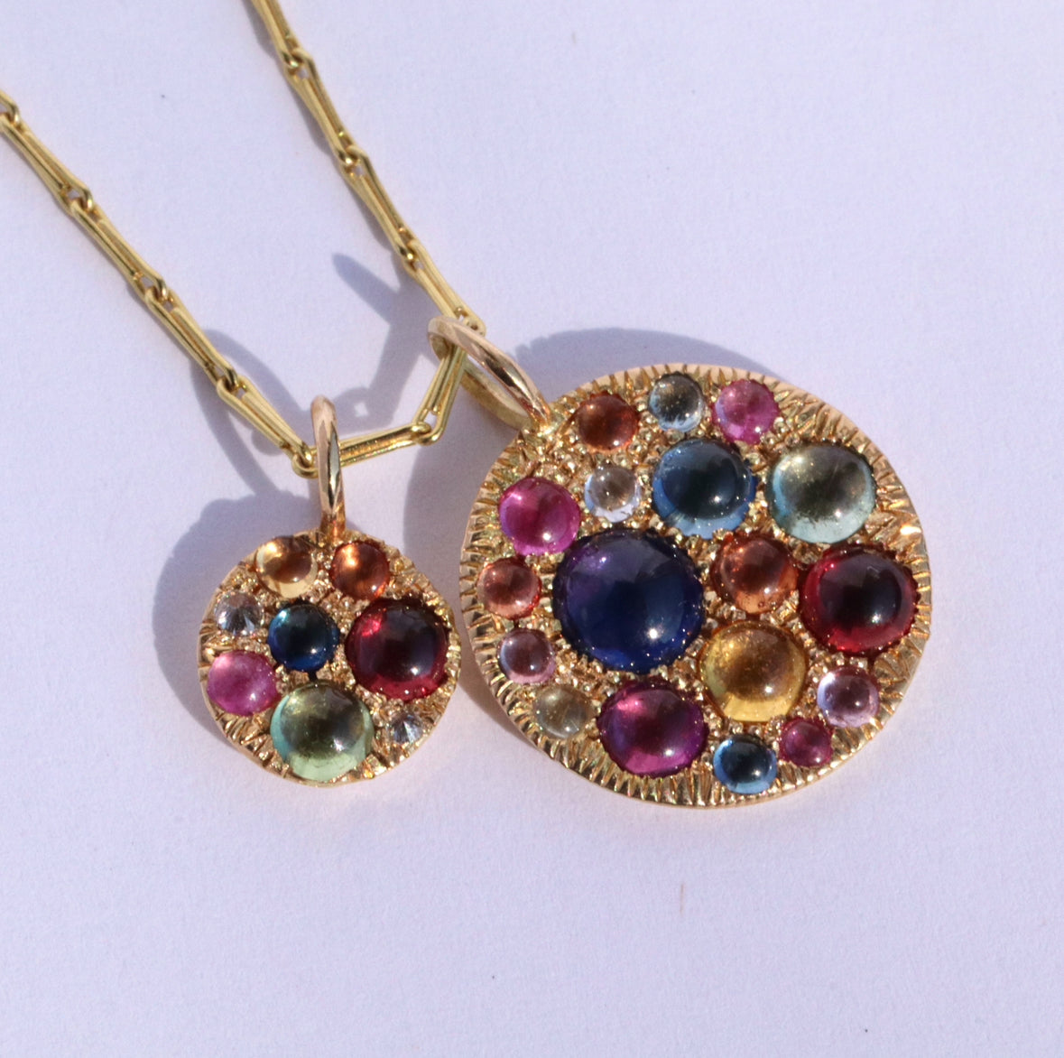 Large and Mini Jelly Bean and Barbed diamond disc pendant on gold barley corn chain against white background