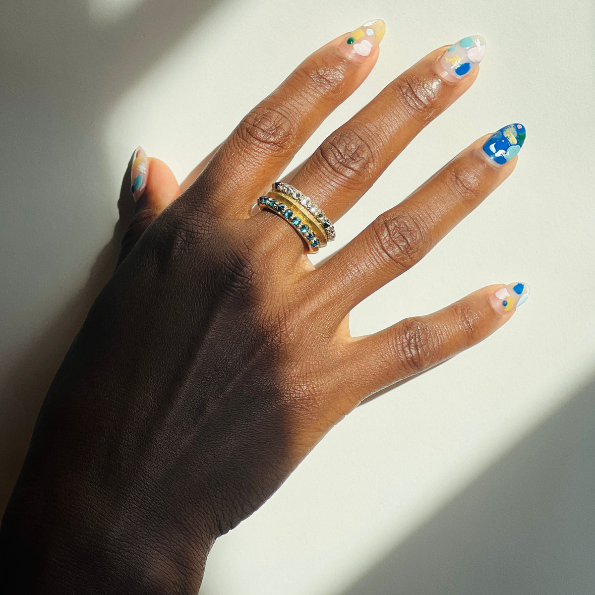 Barbed diamond eternity rings stacked on models middle finger on white background