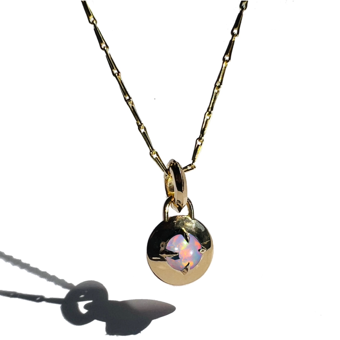 Gold and opal compass pendant necklace by Tamsin Rasor on white background 