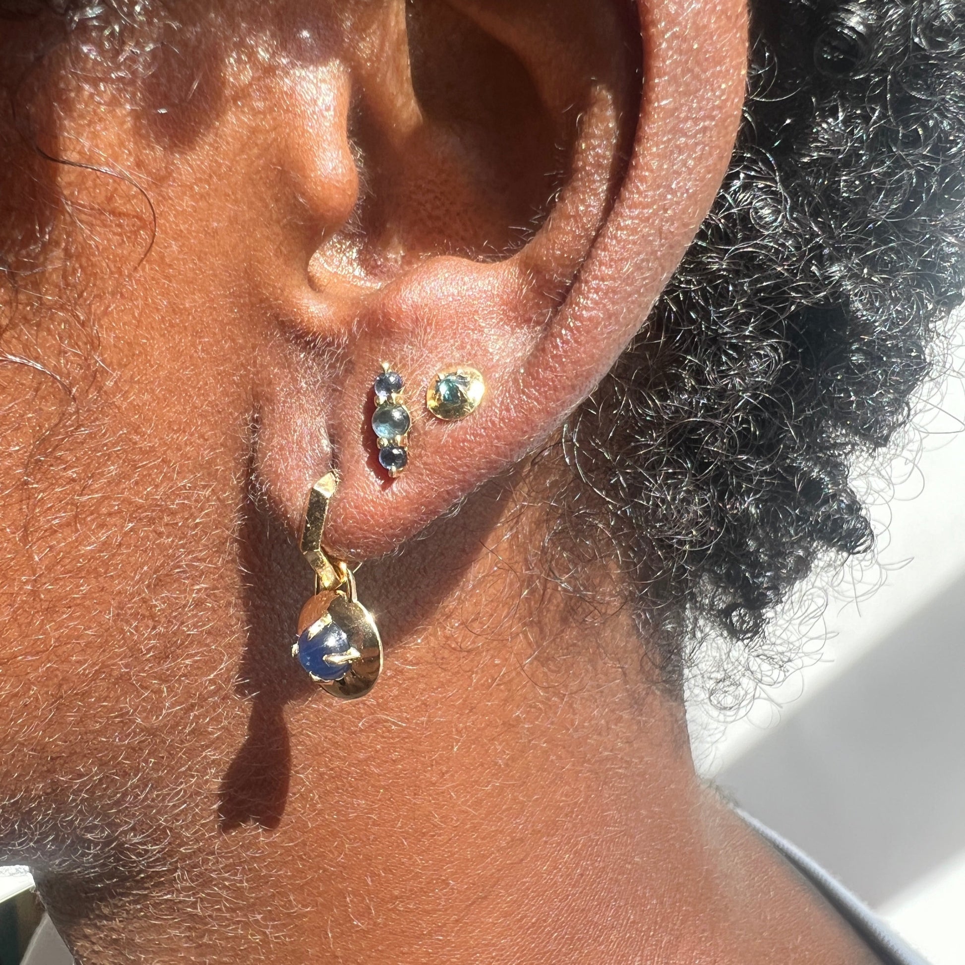 Three sapphire and diamond Earrings on models ear