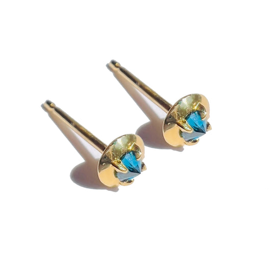 Barbed teal diamond studs on a white background