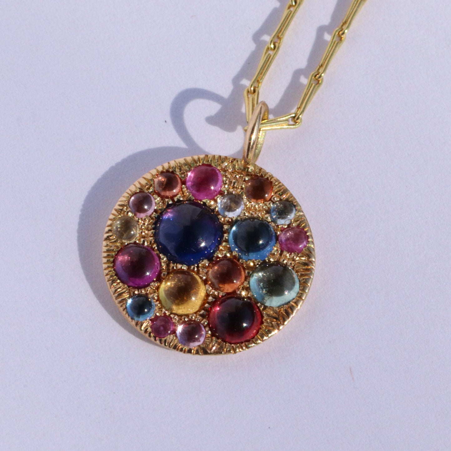 Jelly Bean Sapphire disc pendant on white background