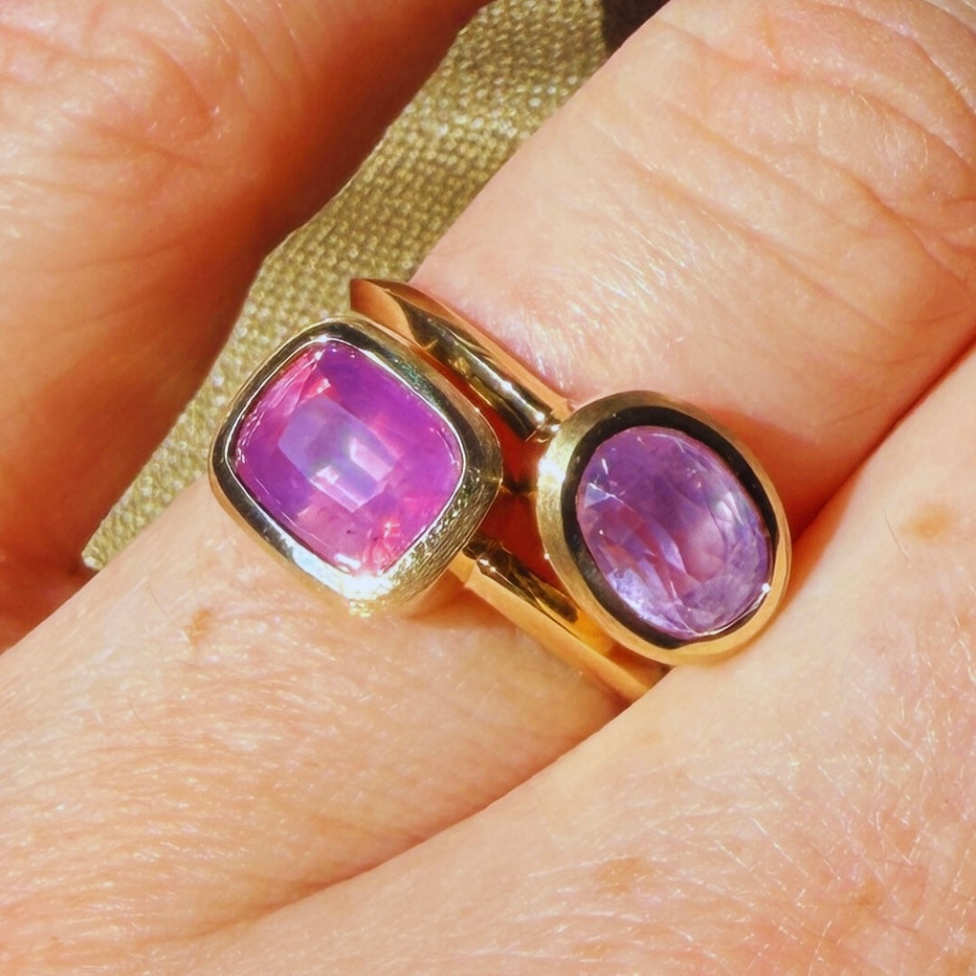 Gold rings with purple and pink sapphire gemstones  by Tamsin Rasor on model's finger