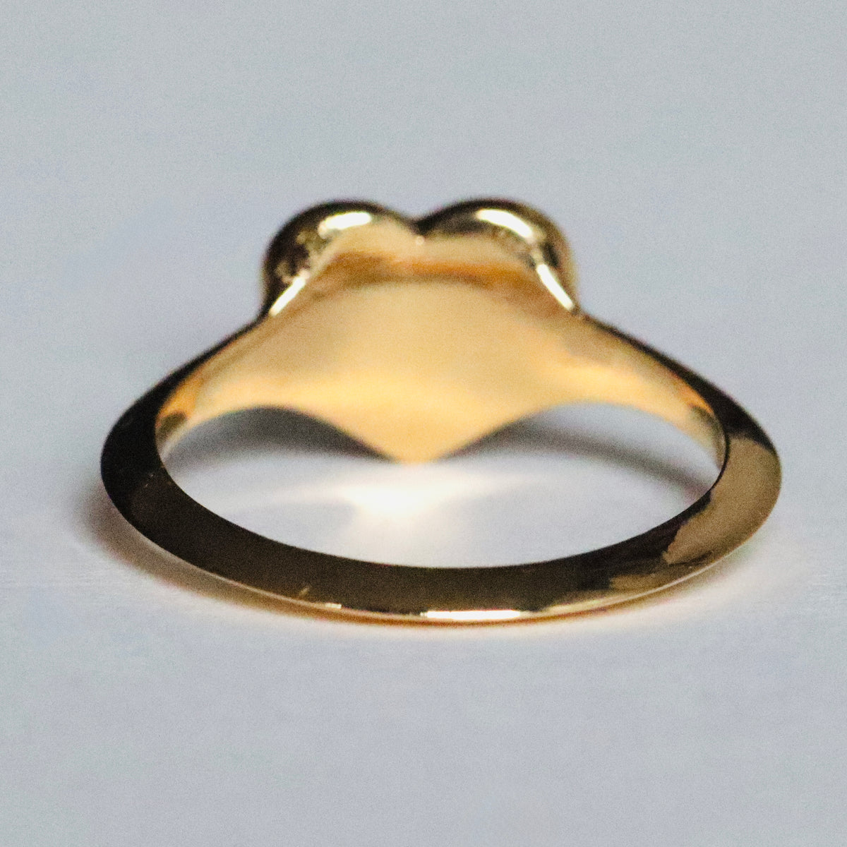 Gold heart-shaped signet ring  by Tamsin Rasor shown  from the back against a white background