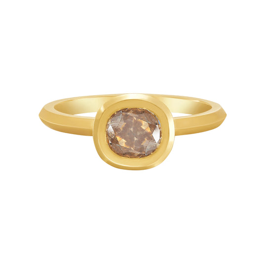 Gold bezel set solitaire ring with a cushion cut champagne color diamond on a white background by Tamsin Rasor