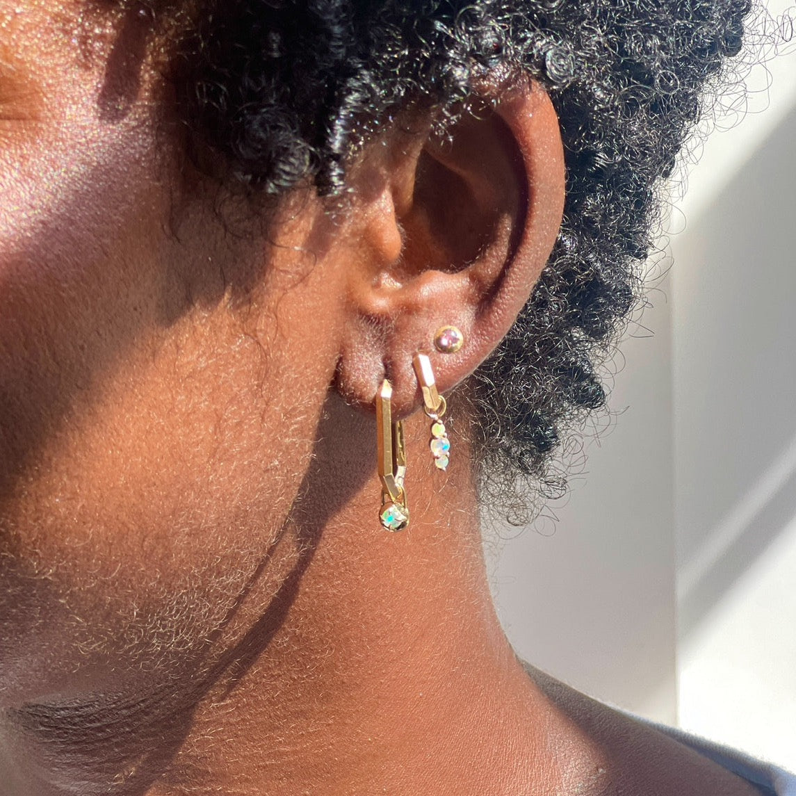 gold makhaira hoops with opal ear charms and sapphire compass stud on models ear