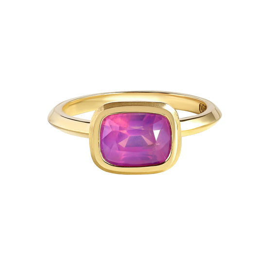 Gold bezel set pink, elongated cushion cut sapphire ring by Tamsin Rasor, on white background