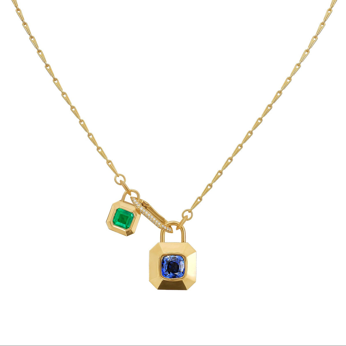 A gold chain necklace featuring two hanging padlock-shaped charms, one with an emerald and the other with a blue sapphire, set against a plain white background, by Tamsin Rasor Fine Jewelry