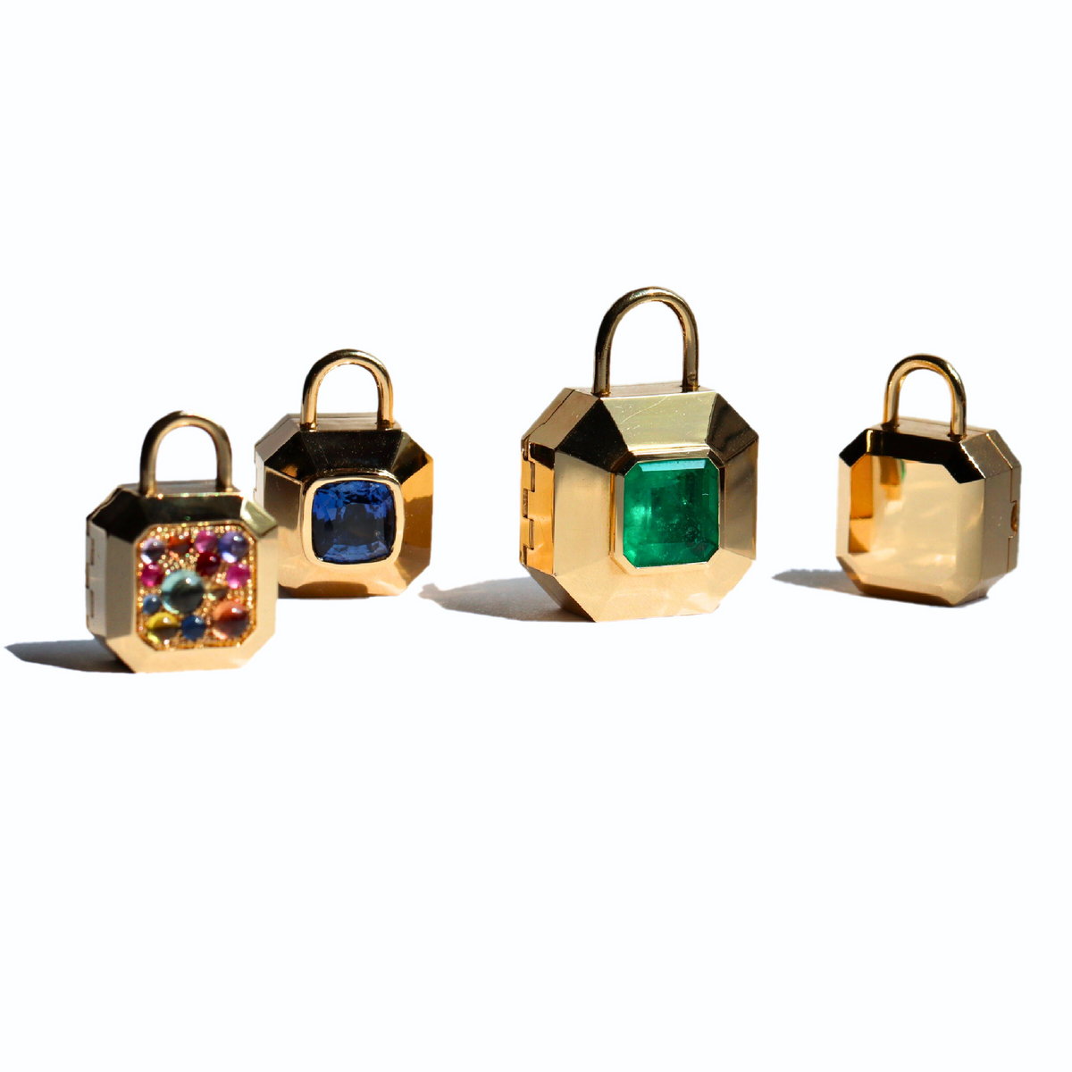 Four different sized colorful gem set 18k gold padlock inspired locket pendants side by side shown on a white background by Tamsin Rasor fine Jewelry