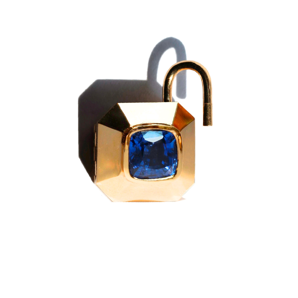 Gold padlock inspired locket pendant with blue sapphire center , with spring loaded bail shown open,  on a white background by Tamsin Rasor fine Jewelry