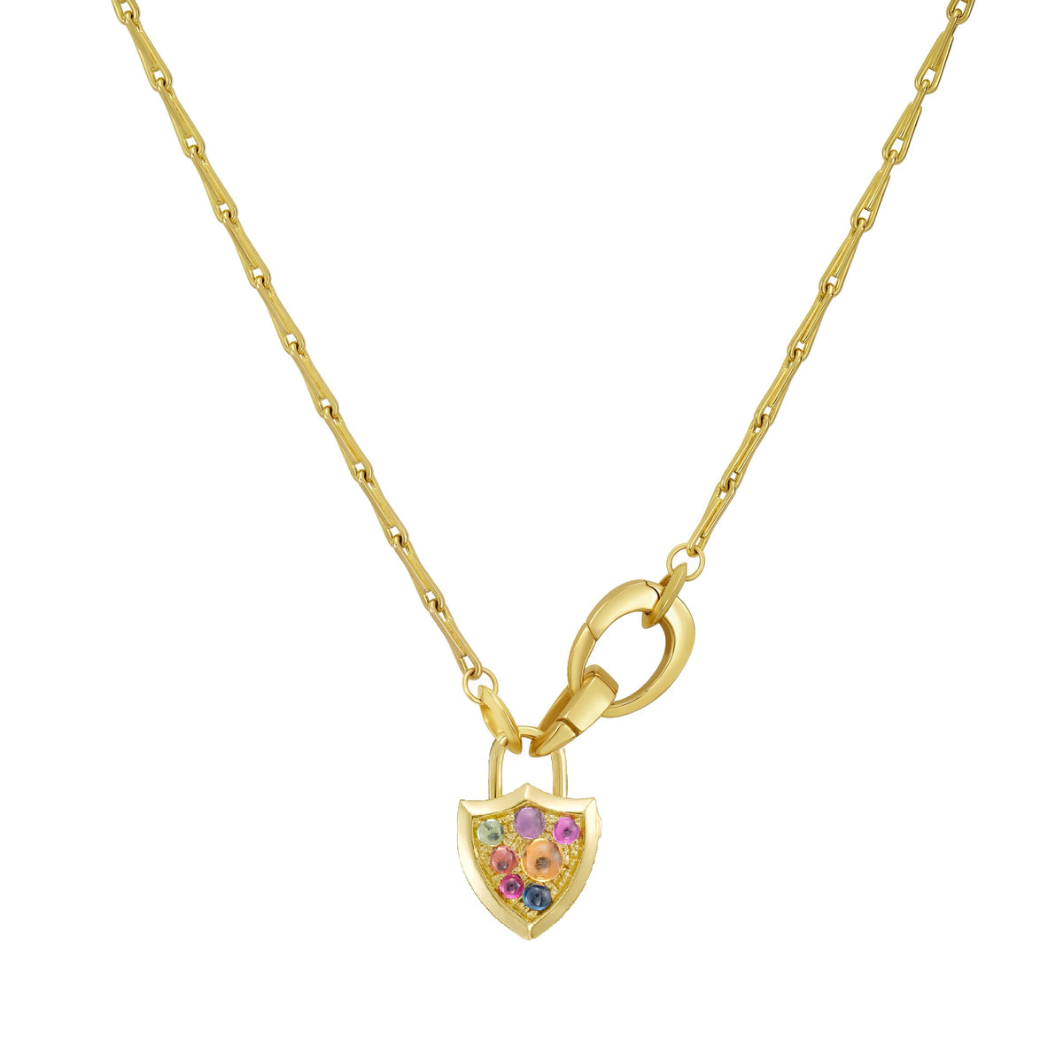 A gold shield-shaped padlock inspired locket pendant , hanging from gold chain with x2 clip bails . The front of the locket is covered in small,  multicolored  cabochon gemstones in pink, purple, blue, and green, set against a plain white background. By Tamsin Rasor