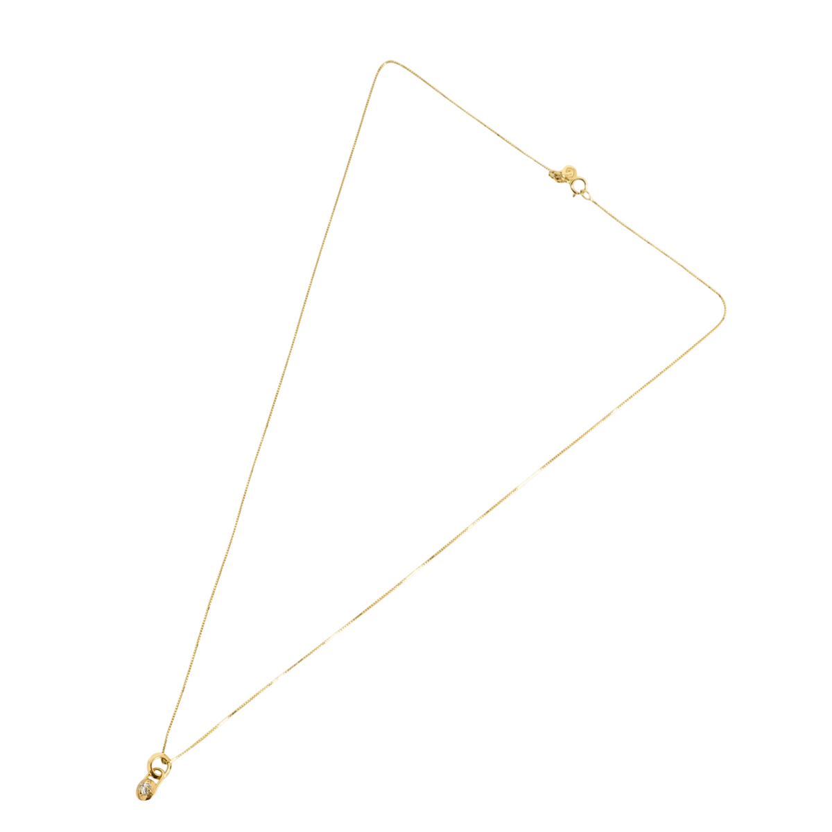 Flat lay of mini gold and diamond compass necklace on white background by Tamsin Rasor