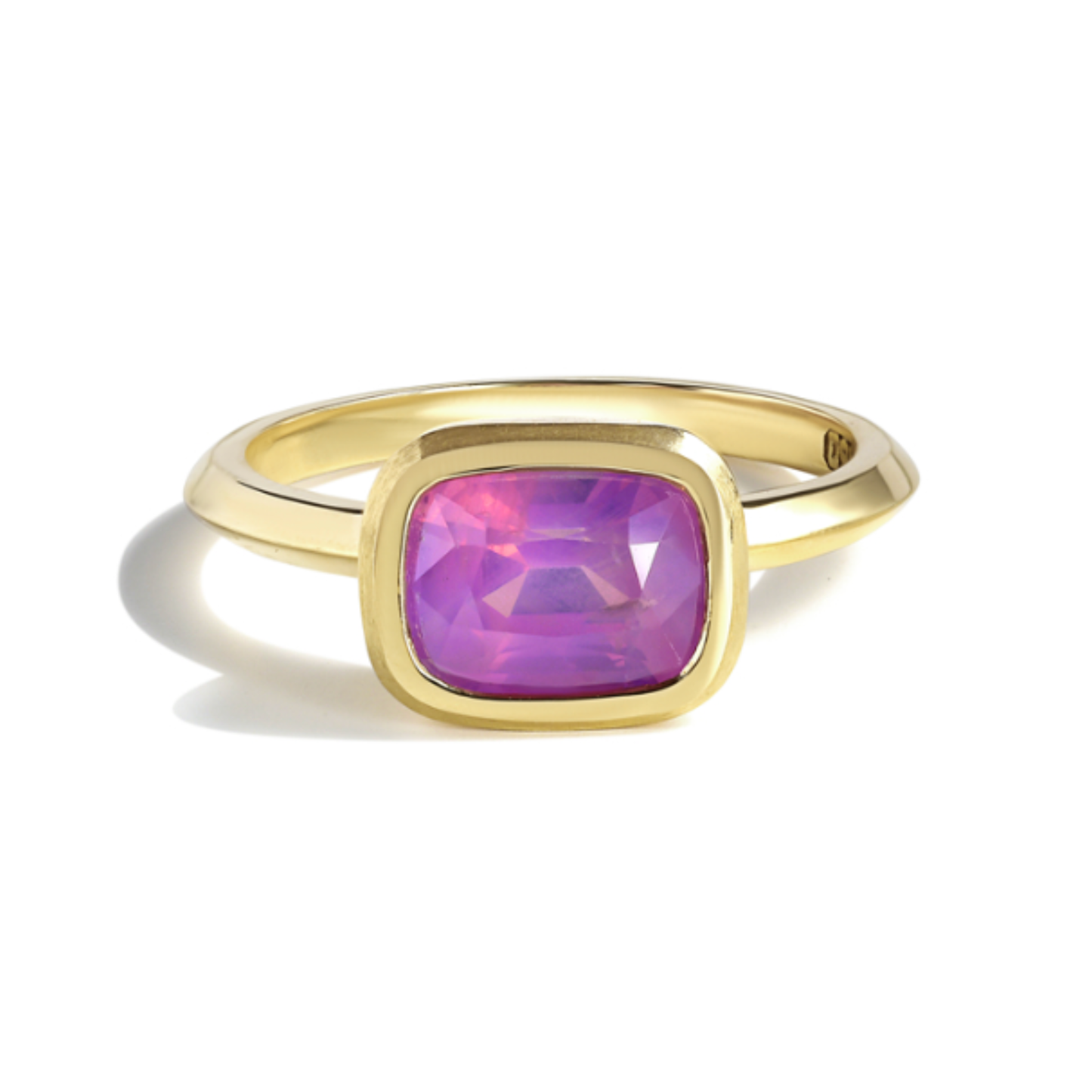 Gold ring with a pink sapphire gemstone by Tamsin Rasor, on a white background