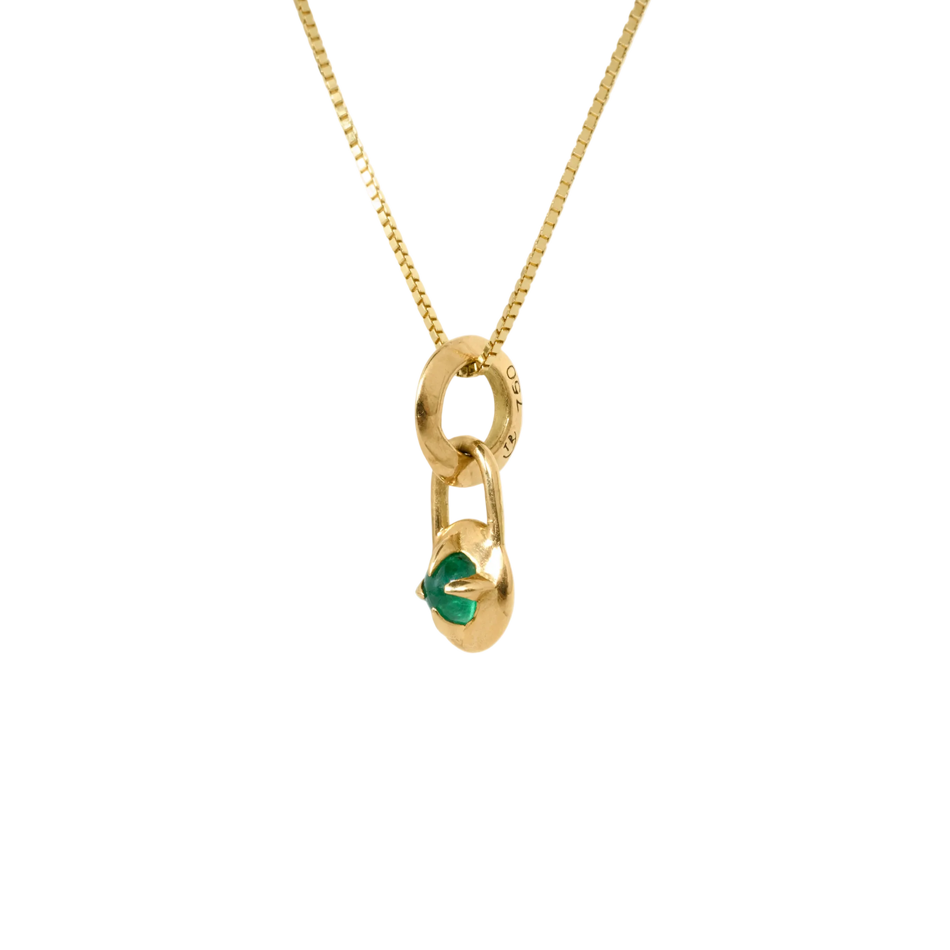 Gold necklace with a compass pendant featuring a natural emerald cabochon, from side,  against a white background by Tamsin Rasor
