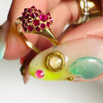 Video of gold and spiky pavé ruby heart shaped signet ring by Tamsin Rasor shown in between models thumb and forefinger