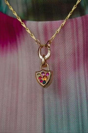 stop motion video showing over seven ways to wear the  puzzle chain and mini shield padlocket locket pendants on models body. Model wears  teal and pink tie-dye shirt.